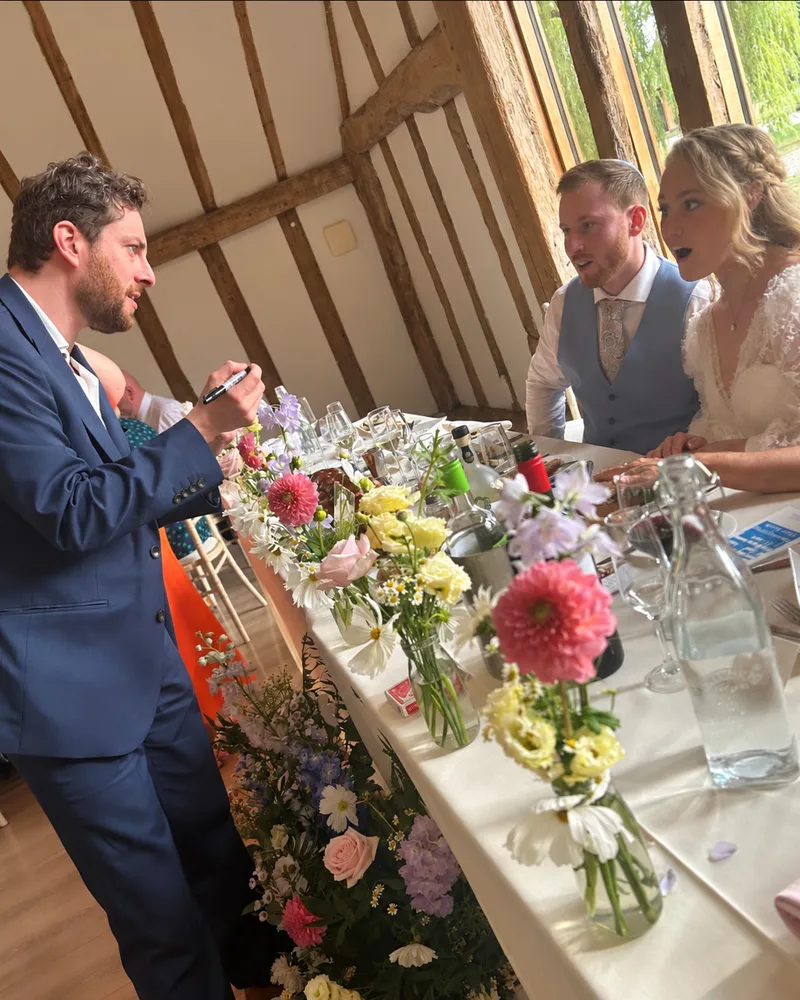 Guy Samuels performing close-up magic for a bride and groom at their wedding table