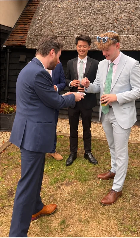 Guy Samuels performing card magic for wedding guests during a drinks reception